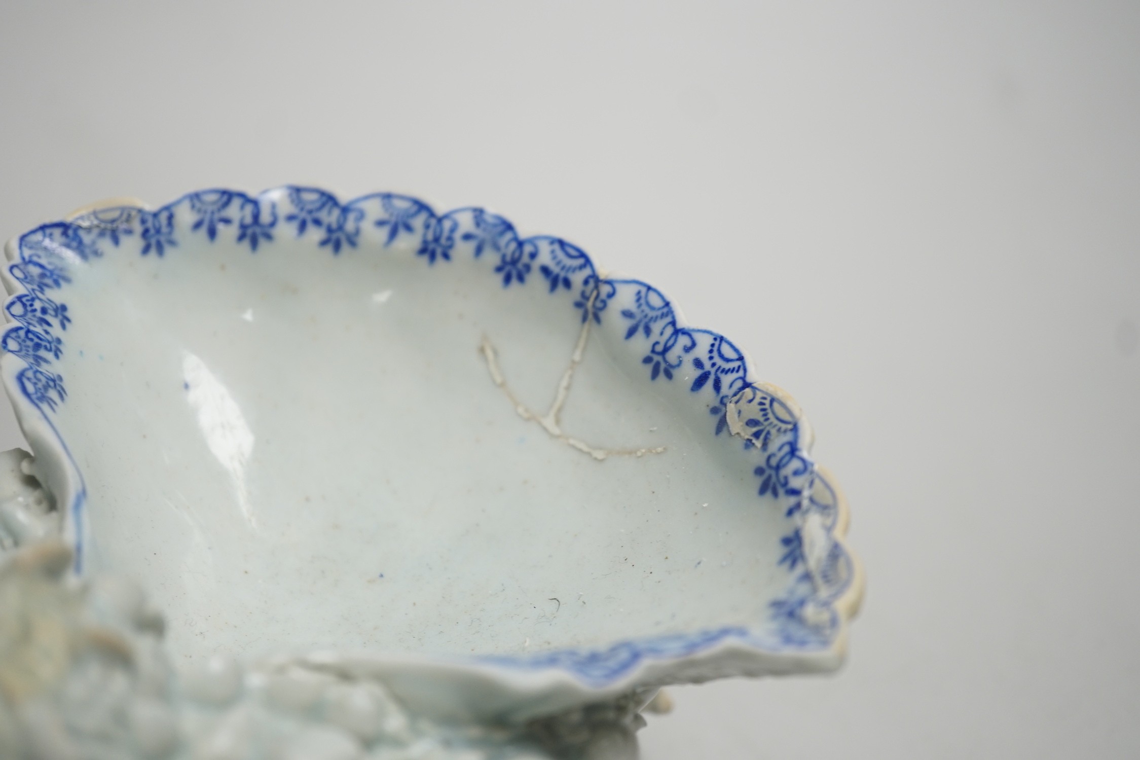 An early Bow porcelain three shell salt, the naturalistically modelled shells picked out in underglaze blue, on a shell and coral encrusted base, 8cm high